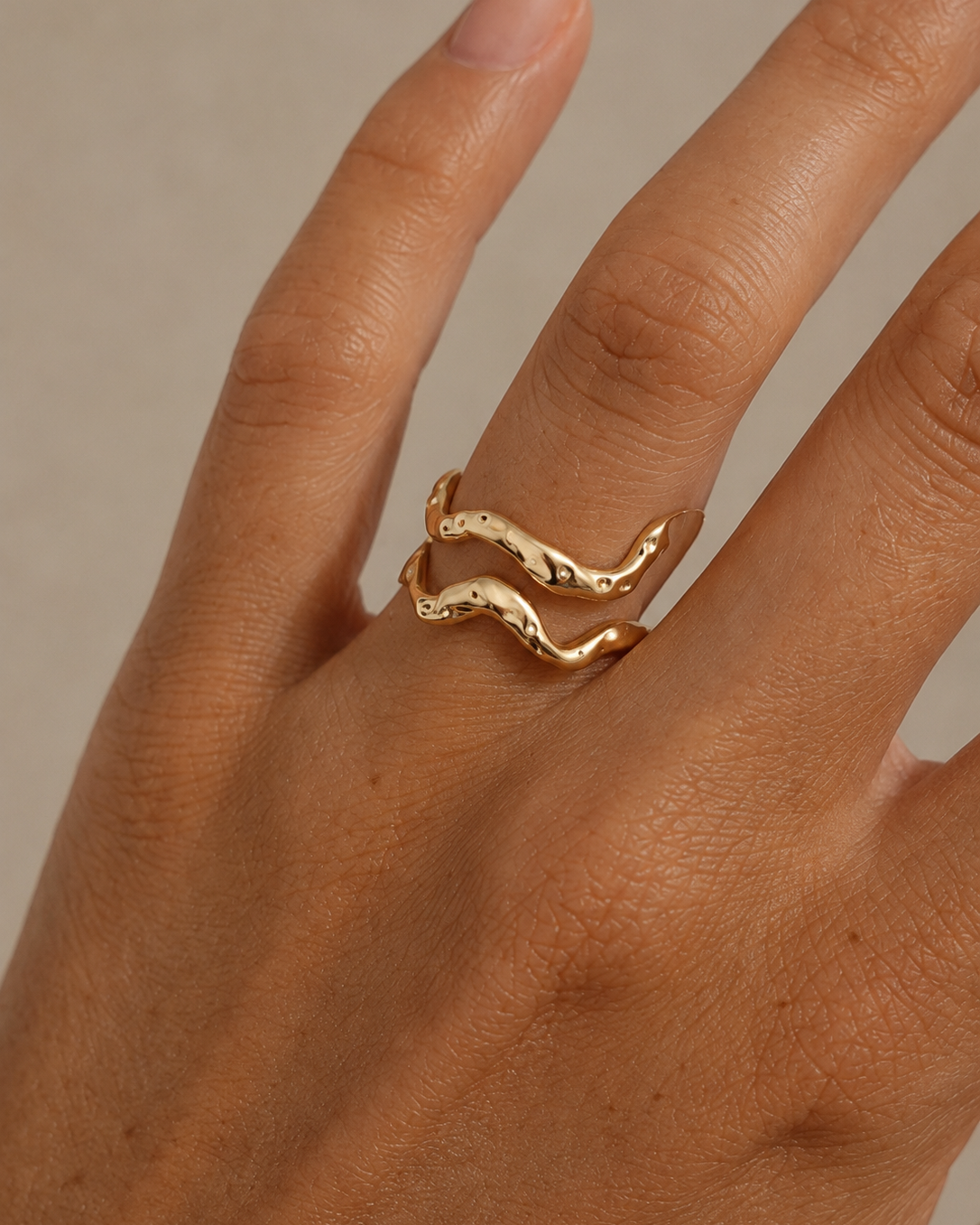 Caspian ring i forgyldt design med åben, bølgende form