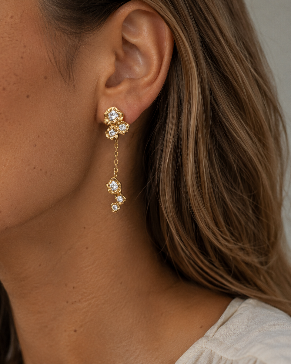 Close-up of gold-plated Elara studs with small stones set one below the other