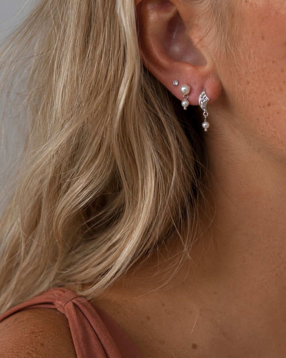 Indu örhängen i silver med fin struktur och liten pärla från Moonshine Collection