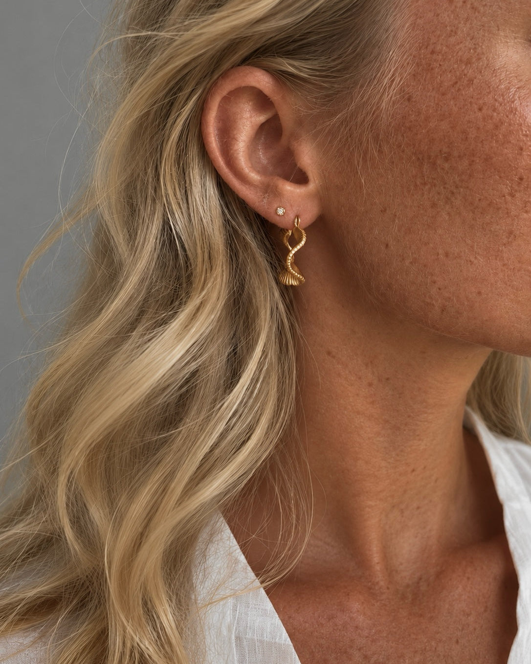Mirage earrings in gold-plated steel with wavy hoop design
