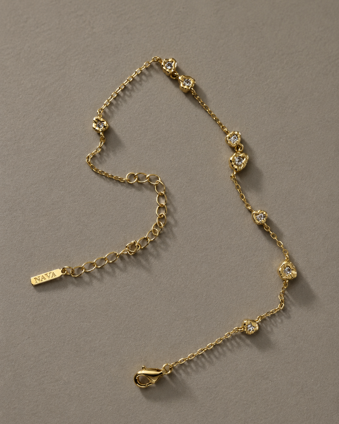 Nalaya gold-plated bracelet lying flat, with small discreet stones