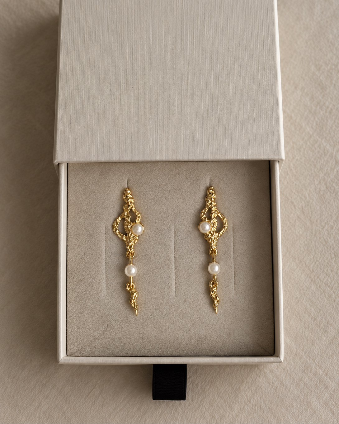 Zale Earrings i forgyldt præsenteret på ske