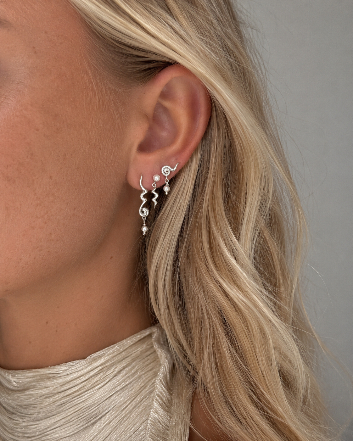 Hayal oorknopjes in sterling zilver met golvende structuur en kleine schelpparel