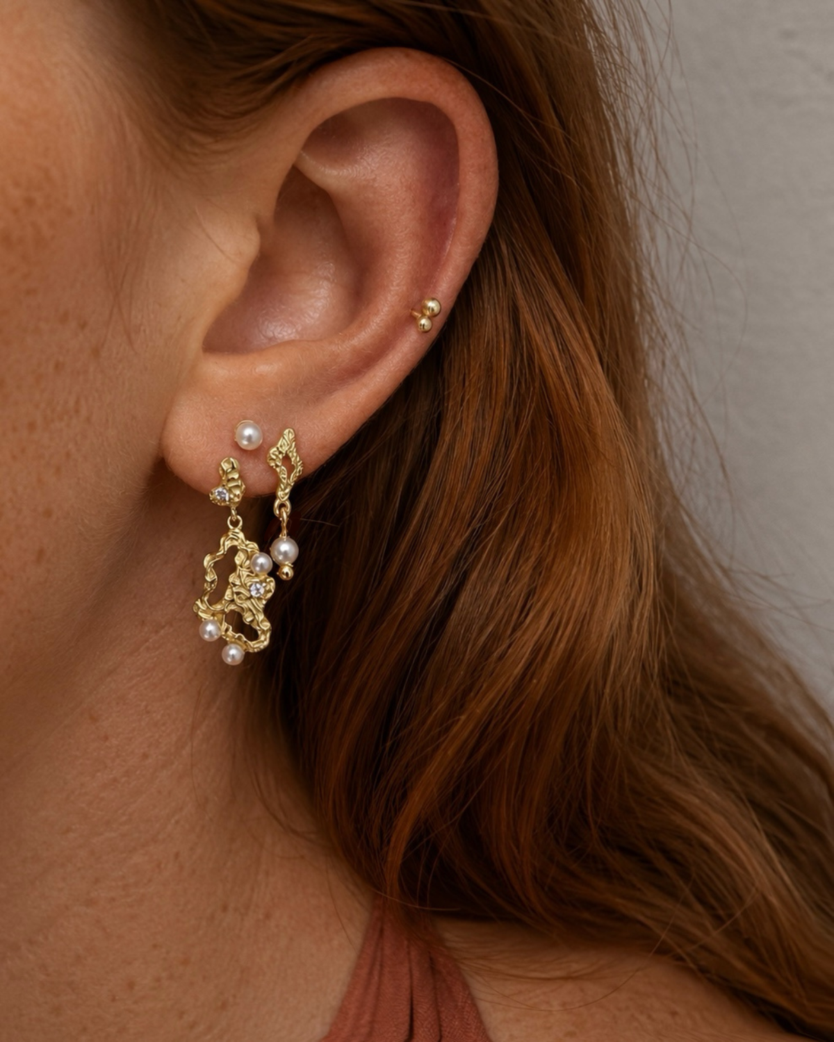 Nærbillede af Makara Earrings i forgyldt med perler og zirkoner