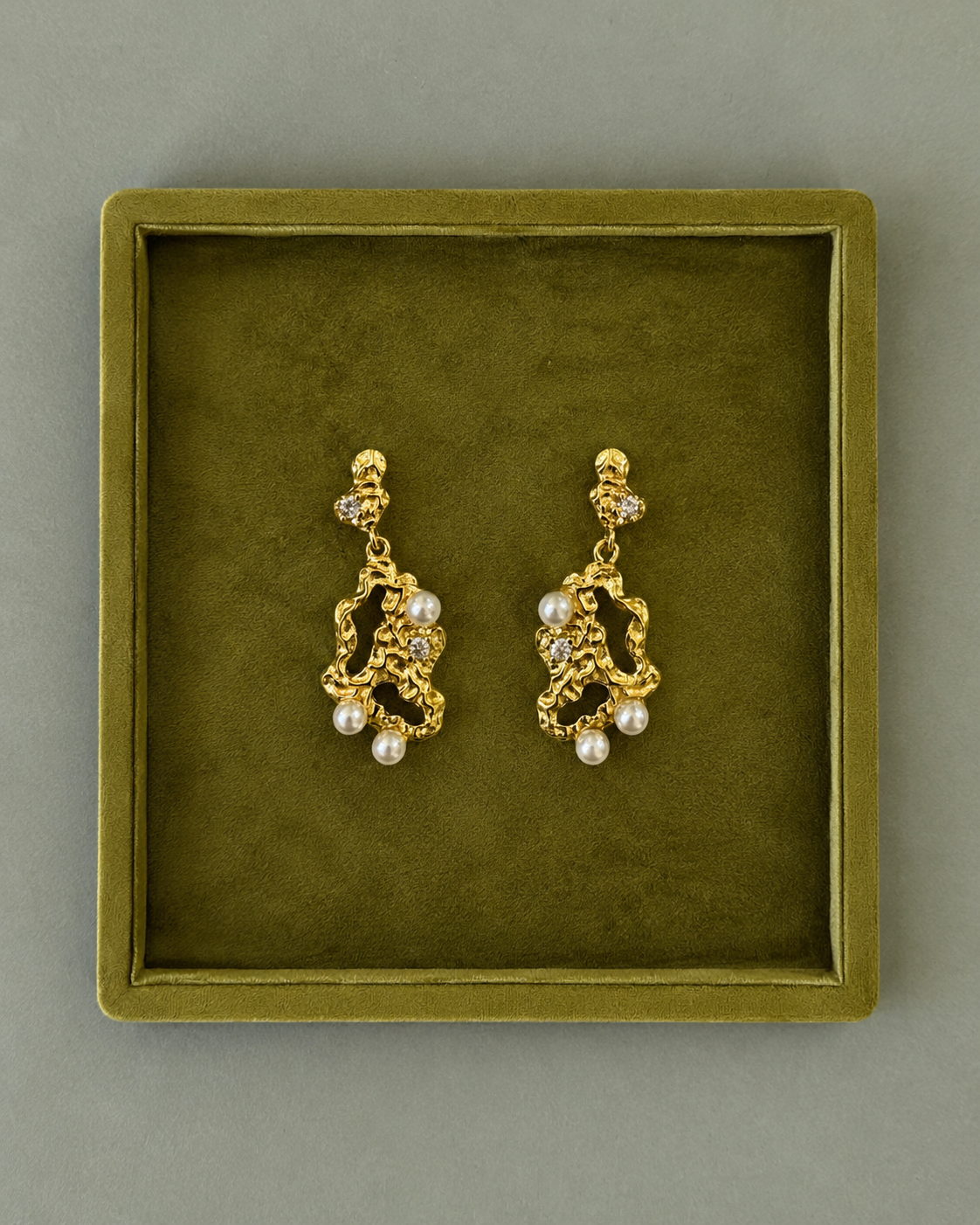 Makara Earrings i forgyldt præsenteret på ske