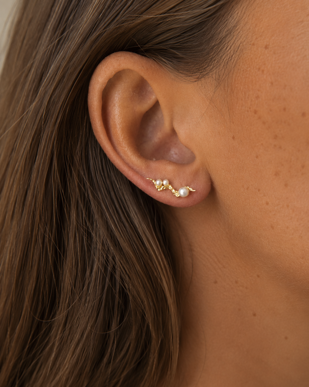 Zephyr ear climbers met golvende vorm en parels in vergulde uitvoering