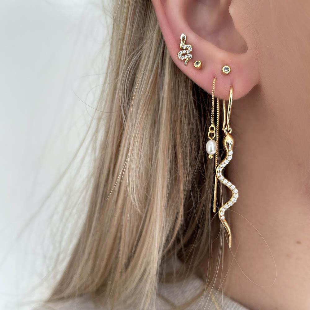 Because of their enchanting designs our Boa Earrings are some of our absolut bestsellers. Boa Earrings are long snake earrings filled with clear cubic zirconia, which creates the perfect mix of raw and feminine. Style them alone or together with some of our other earrings to create a stacked look. 