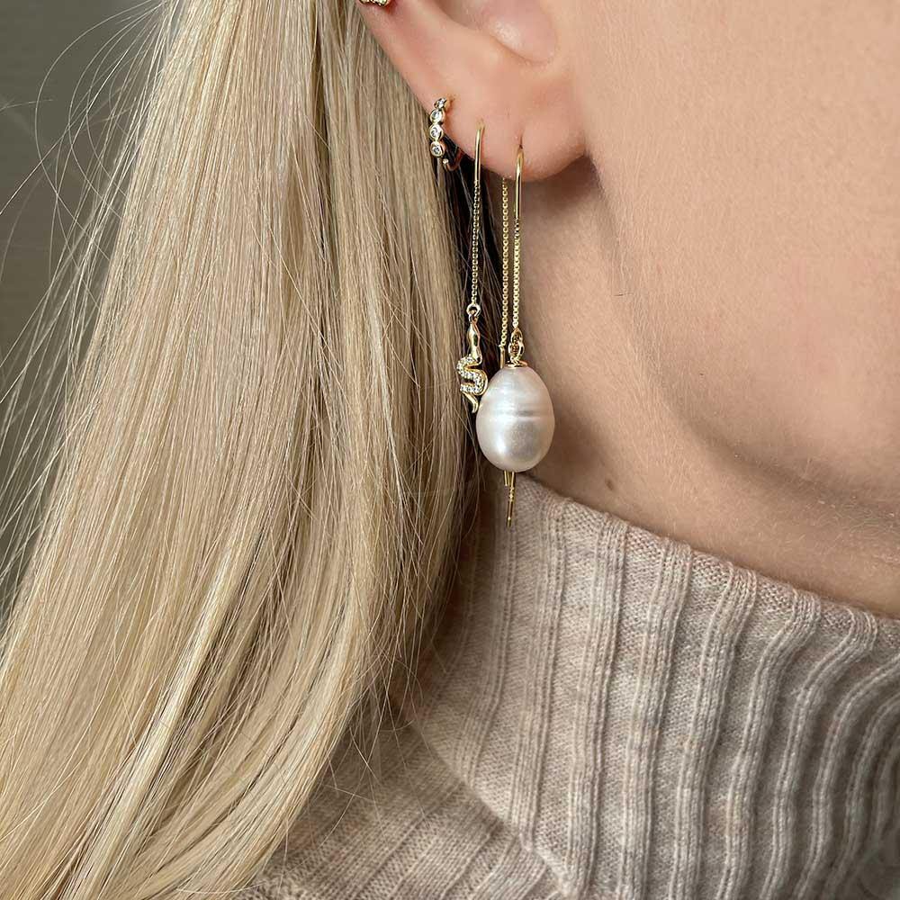 Coco Earrings are with the classic and timeless design an absolut bestseller. The earrings has a large baroque freshwater pearl, which makes the earring unique as no pearls are the same. Even though the pearls are large, its not heavy to wear and the design of the chain makes the earring stay in place. Use it alone or style it with other ear threads.  Note that the freshwater pearls are natural and may differ in shape, color and size.