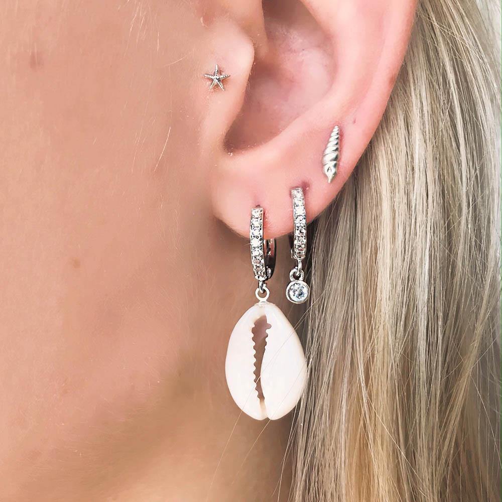Our beautiful Petite Conch Stud is a small stud formed as a conch. The earring will have you longing for the beach. It's a perfect detail to your summer outfit. It's stunning alone but can easily be styled with other earrings.
