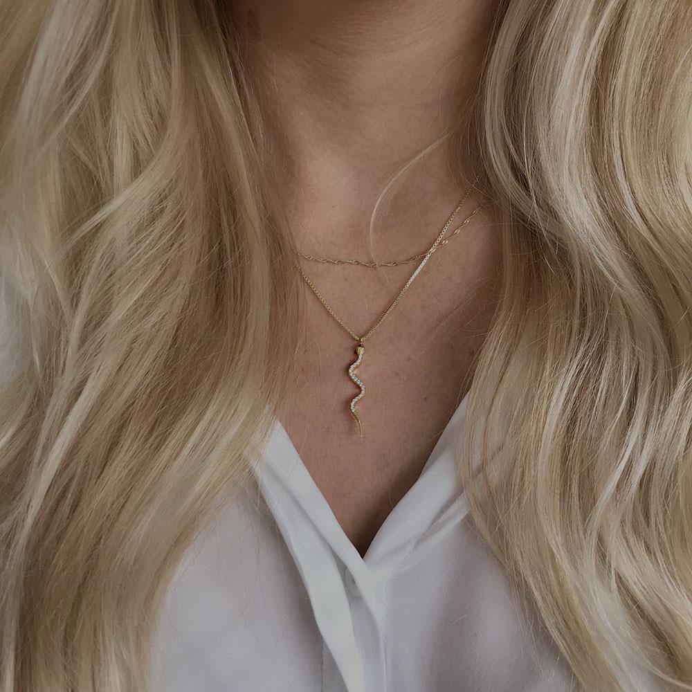 Boa Necklace is an enchanting necklace with a long snake pendant filled with clear cubic zirconia. The necklace is raw and feminine and can be styled alone or with other chains. 