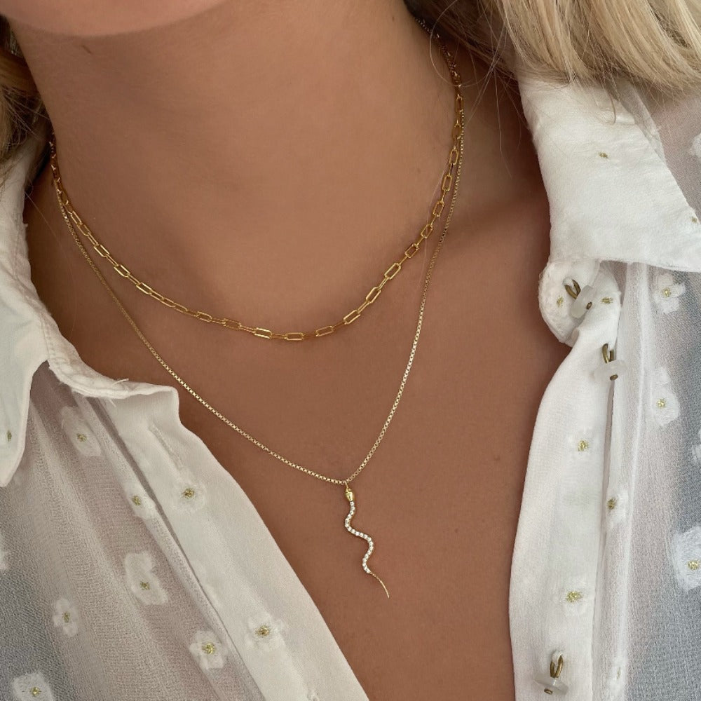 Boa Necklace is an enchanting necklace with a long snake pendant filled with clear cubic zirconia. The necklace is raw and feminine and can be styled alone or with other chains.