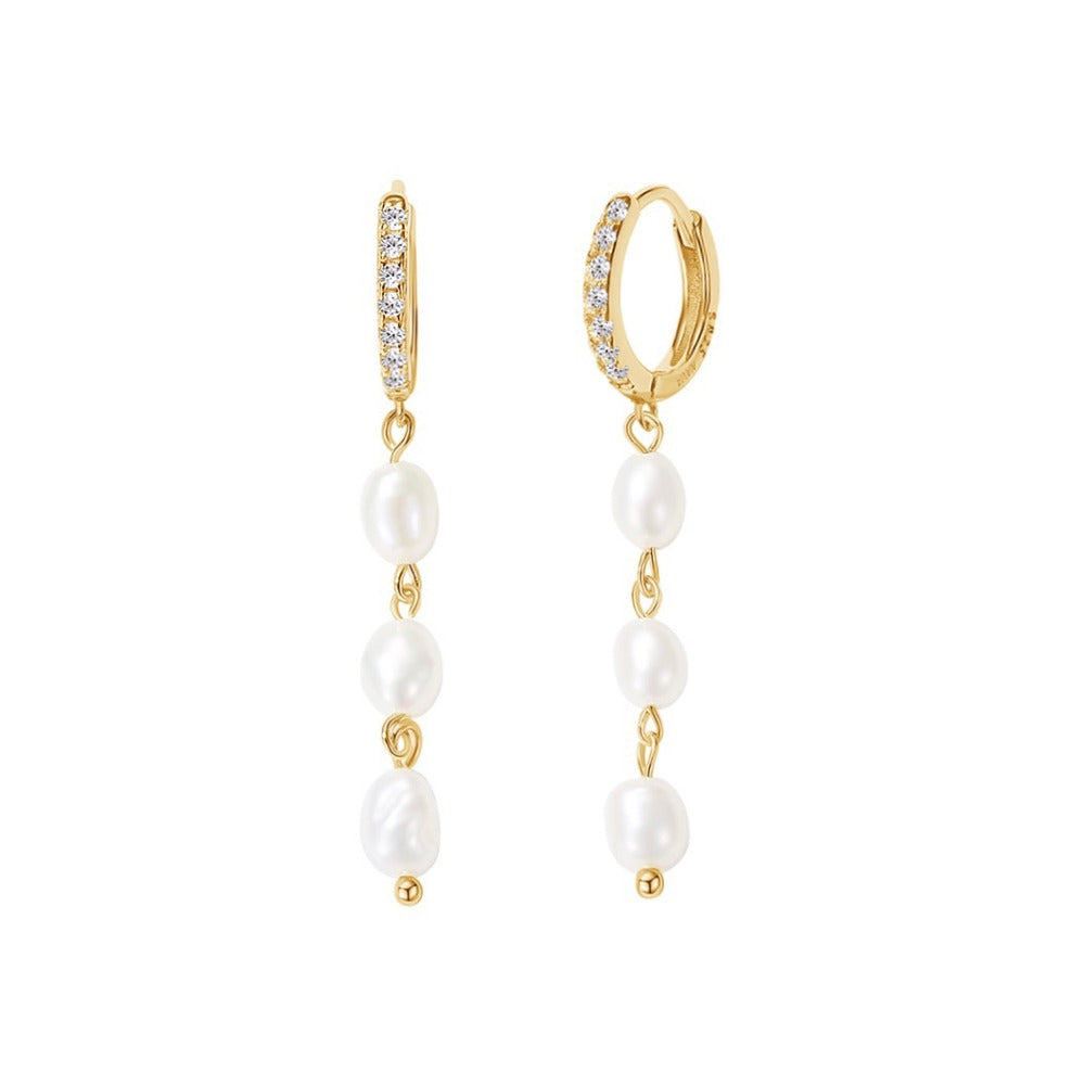Our Nora Earrings are longer huggie earrings with three floating freshwater pearls. The earring is beautiful and unique and will definitely spice up your outfit. The earrings are easy to put in because of the huggie style. Use it alone or style it with your other favorite earrings.